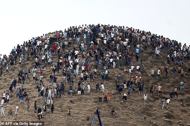 People gather on a hilltop close to the site of clashes near Fnideq, on the Morocco-Spain border, on July 31, 2026