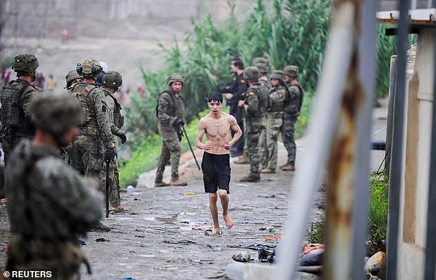 A topless migrant from Morocco arrives at the Spanish border in Ceuta, Spain