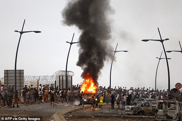 A vehicle burns at the site of clashes between migrants and security forces near Fnideq, on the Morocco-Spain border
